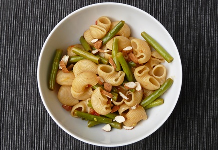 Zitronige Nudelpfanne mit Buschbohnen, Zwiebeln, Knoblauch und gehackten Mandeln