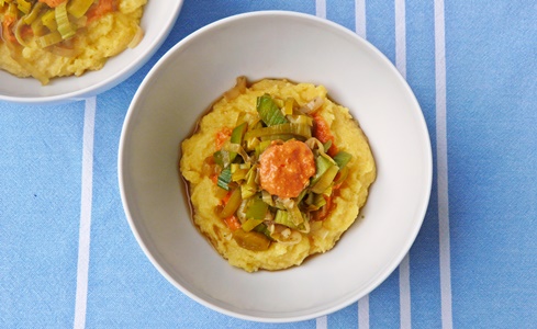 Polentaschüssel mit geschmortem Lauch und Pesto aus frischen und getrockneten Tomaten