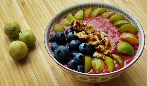 Smoothie-Bowl mit Himbeeren, Heidelbeeren, Mirabellen und Walnüssen