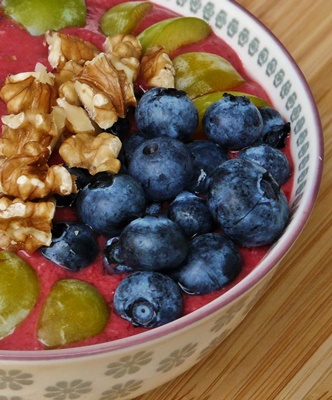 Smoothie-Bowl mit Himbeeren, Heidelbeeren, Mirabellen und Walnüssen