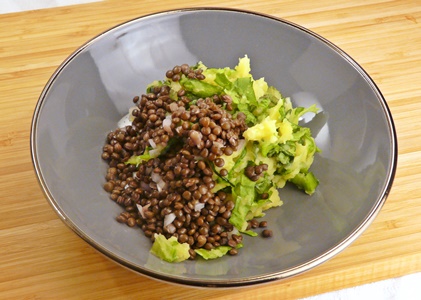 Eine meiner engsten Freundinnen hat mir vor einiger Zeit erzählt, dass sie Gemüsereste gerne als Stamppot verarbeitet. Dieses niederländische Gericht besteht aus gekochten Kartoffeln, die mit Gemüse zerstampft werden. Für Andijviestamppot wird Endiviensalat unter Karoffelpürree gehoben. Dazu werden oft Frikadellen, Würste oder Speckstreifen gegessen, besagte Freundin hat berichtet, dass sie zu Stampftöpfen gerne Räuchertofu anbrät. Mein Andijviestamppot ist sehr einfach und besteht nur aus Kartoffeln, Endivien, Wasser und Gewürzen. Dazu habe ich warme Belugalinsen serviert, die mit Essig, Öl und gehackten Zwiebeln angemacht waren. Gemeinsam werden Linsen und Stampf eine deftige, vegane Mahlzeit, die perfekt zur kalten Jahreszeit passt. Endivien-Stamppot mit sauren Belugalinsen für 2 Portionen Zutaten: 100 g Belugalinsen (trocken) 1 Schalotte 3 EL Apfelessig (evtl. mehr) 1 EL Sonnenblumenöl 600 g Kartoffeln (mehligkochend) 300 ml Wasser 350 g glatte Endivie Salz, Pfeffer, Muskatnuss Zubereitung: Die Linsen nach Packungsangabe kochen. Die Schalotte abziehen und fein hacken. Kartoffel schälen und in große Würfel schneiden. In einen Topf geben und im gesalzenen Wasser weich kochen. In der Zwischenzeit den Endiviensalat putzen, waschen und in feine Streifen schneiden. Die gegarten Kartoffeln im verbliebenen Kochwasser zerstampfen, die Endivienstreifen unterheben, dabei fallen sie nach und nach deutlich zusammen. Den Stamppot mit Salz, Pfeffer und frisch geriebener Muskatnuss würzen. Die warmen Linsen mit Essig, Öl und Schalottenwürfeln verrühren, mit Salz, Pfeffer und eventuell etwas mehr Apfelessig abschmecken. Stamppot auf zwei Schüsseln aufteilen und saure Belugalinsen darüber geben. Veganer Endivien-Stamppot mit sauren, warmen Belugalinsen