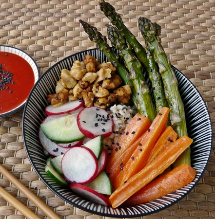 Bibimbap vegan: Reisschüssel mit grünem Spargel, Karotten, Gurken, Radieschen und Tempehbröseln