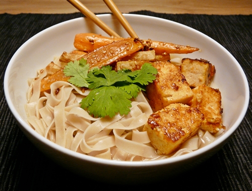 Vegane Reisbandnudelsuppe mit würziger Brühe, Sriracha-marinierte Tofuwürfeln und geröstetem Sesam-Wurzelgemüse