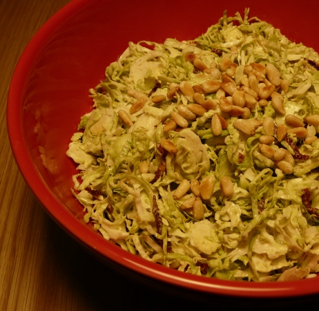 Veganer Salat aus rohem Rosenkohl mit Hanfsamen-Dressing, getrockneten Tomaten und Pinienkernen